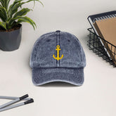 Vintage cotton twill cap with yellow anchor embroidery on a desk with plants and stationery, showcasing a stylish low-profile design.