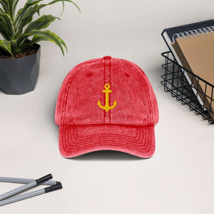 Vintage cotton twill cap with anchor embroidery, displayed on a desk with plants and stationery.